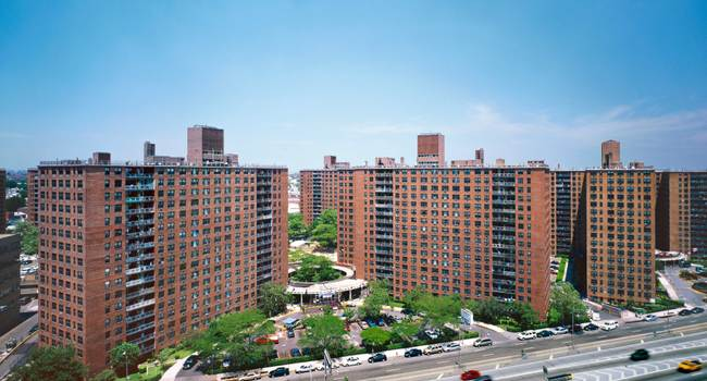 3-4 large aparment buildings under a blue sky.